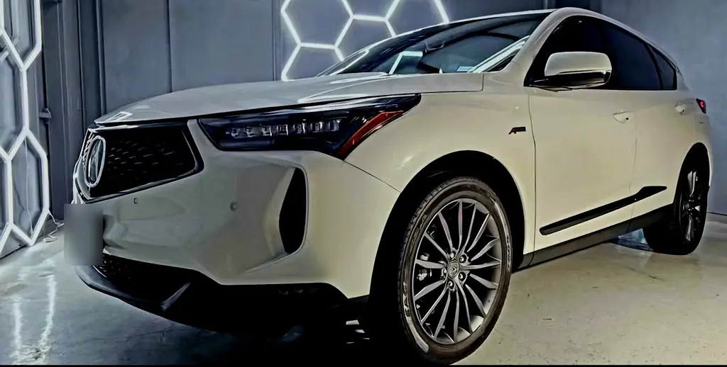 White Acura SUV parked under the hexagon LED lights inside the Lewisville studio
