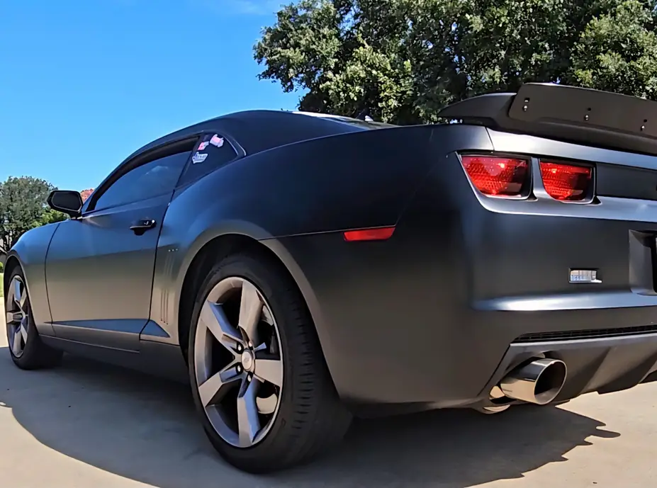 Matte black Camaro rear quarter under studio light